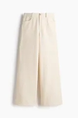 Pantalón amplio color crudo confeccionado en punto bouclé, con elástico oculto en la cintura, cierre decorativo con botón, bolsillos delanteros y bolsillos de parche en la parte trasera.