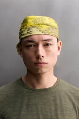 Bandana cuadrada confeccionada en tejido ligero de mezcla de ramio y algodón, con diseño de patchwork que combina paneles con estampados florales y paisley en tonos amarillo, mostaza y verde militar.