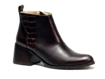 Bota corta de cuero vacuno color marrón oscuro, con taco campana y detalle de textura símil cocodrilo en la parte trasera. Cuenta con cierre lateral y tirador en el talón.