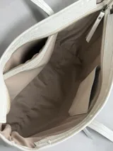 Bolso tipo shopper de cuero natural con textura simil cocodrilo, asas dobles largas para el hombro y bolsillo exterior con cierre en la parte frontal.