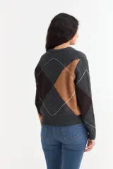 Sweater de punto con diseño de rombos en tonos gris, marrón y negro, con cuello en V y mangas largas.
