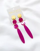 Aros colgantes con piezas circulares doradas y fucsia, y pieza alargada fucsia.