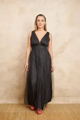 Vestido largo de fiesta, confeccionado en microtul negro con detalles plateados, doble escote en V y volado en gajos.