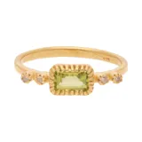 Anillo dorado con una piedra central rectangular de color verde claro (peridoto) y dos diamantes a cada lado. Elaborado en plata 925 bañada en oro 18k.