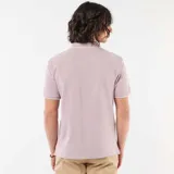 Remera polo de piqué color lila, con cuello camisero y ribetes blancos en el cuello y las mangas. Cuenta con cierre frontal parcial de dos botones y pequeño logo bordado en el pecho.