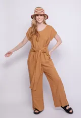 Mono color ocre de lino y viscosa, con botones veteados, manga corta, dos bolsillos laterales y lazo para atar a la cintura.