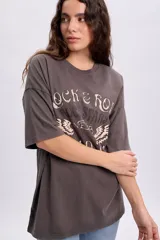 Remera oversize gris claro de manga corta, con estampa frontal inspirada en el rock con inscripciones y alas.