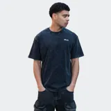 Remera negra con efecto acid wash y logo estampado en el pecho.