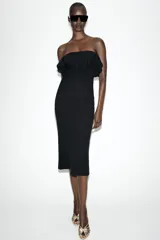 Vestido midi negro de punto con escote de hombros descubiertos adornado con volantes y diseño ajustado.