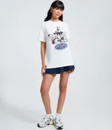 Remera blanca de manga corta y cuello redondo, con un estampado central que presenta a Mickey Mouse y sus amigos (Goofy, Minnie, Donald, Daisy, Pluto) en estilo deportivo, con el texto "Mickey & Friends" y la frase "Never Get Out Of Style".