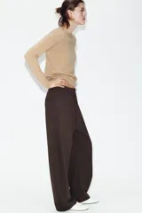 Pantalón de tiro alto con diseño tipo balloon, cintura con trabillas, bolsillos laterales y cierre frontal con cremallera y botón.
