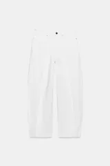 Jeans blancos de tiro medio y pernera ancha con corte barrel que se estrecha hacia el tobillo. Presenta cinco bolsillos, pliegues delanteros y cierre frontal con cremallera y botón metálico.