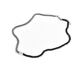 Collar corto de cuentas facetadas grises y negras, con una perla blanca descentrada.