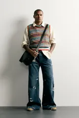 Chaleco de punto tejido en hilatura de algodón con diseño patchwork de patrones jacquard multicolores, cuello redondo y terminaciones en rib.