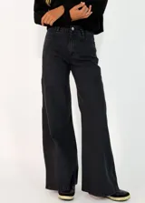 Pantalon de jean negro de corte wide leg, con tiro alto, cierre frontal con botón y bolsillos laterales.