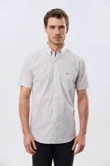 Camisa de manga corta con microcuadros en tonos celestes y blancos, calce slim, cuello con botones y bolsillo frontal con logo bordado.