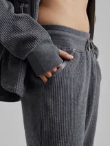 Pantalón de jogging gris con textura acanalada y corte holgado.