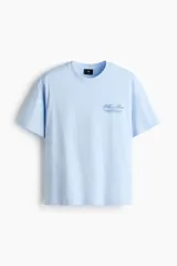 Remera celeste de corte holgado, con cuello redondo y diseño estampado en el pecho.
