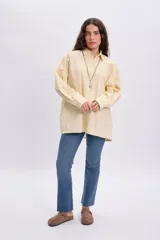 Camisa casual de color amarillo claro, con cuello clásico, mangas largas y cierre frontal de botones.