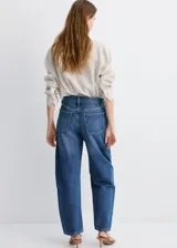Jeans de denim azul de corte wide leg y tiro medio, con diseño clásico de cinco bolsillos y cierre frontal con botón y cremallera.