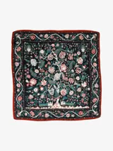 Pañuelo cuadrado de seda con estampado floral y de aves en tonos verdes, rojos y blancos sobre fondo negro, con borde rojo.
