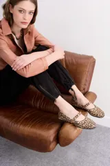 Balerina de cuero con estampado animal print de leopardo, con tira sobre el empeine y remaches de níquel de distintos tamaños. Suela con plantilla acolchonada.