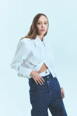 Jean de tiro bajo y corte oversize, confeccionado en denim azul con monograma grabado a láser en toda la prenda. Presenta doble botón metálico en la cintura y diseño de cinco bolsillos.