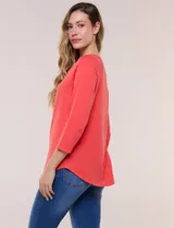 Remera blanca de algodón con elastano, de corte semi holgado, escote bote con ojalillos metálicos frontales, mangas tres cuartos raglán y ruedo asimétrico curvado.