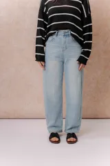 Jean wide leg de tiro alto en denim color celeste claro. Presenta un diseño de cinco bolsillos, destacándose los bolsillos traseros con solapa y detalle de marca metálica. Posee cierre frontal con botón y ruedo recto.