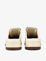 Zapatillas Autry Medalist Mule, de cuero blanco con puntera perforada y detalles en cuero marrón. Tiene suela de goma color crema y logo de la marca en el lateral.