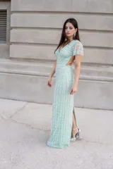 Vestido largo de micro tul color verde agua, bordado con piedras y lentejuelas en patrón geométrico. Cuenta con escote en V, mangas cortas fluidas y silueta ajustada.