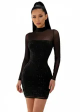 Vestido corto ajustado de color negro, con diseño de cuello alto y mangas largas en tela de tul transparente. El cuerpo del vestido presenta un patrón de pedrería rectangular brillante sobre una base opaca.