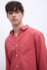 Camisa celeste de algodón, corte regular fit, con cuello solapa clásico, manga larga, bolsillo en el pecho y botones personalizados.