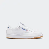 Championes Reebok Club C 85 blancos de cuero con detalles en azul y suela de goma color caramelo.