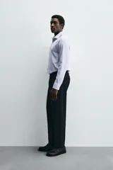 Camisa de manga larga, color celeste con finas rayas verticales blancas, cuello italiano y cierre frontal de botones.