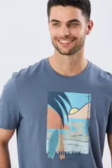 Remera gris de manga corta con cuello redondo y estampa frontal de paisaje costero con tablas de surf y la leyenda "Having Fun".