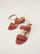 Sandalias de gamuza color bordó con taco bloque de charol, tiras con pespuntes artesanales en cuero y tira fina ajustable al tobillo.