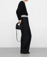 Pantalón ancho negro con pinzas en el delantero, bolsillos laterales y de vivo en la espalda, de pierna recta y tiro alto con cinturilla interior en tejido de rayas a contraste.