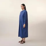 Vestido largo azul a rayas verticales, con cuello mao, mangas largas y corte evasé.