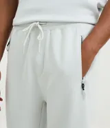 Pantalón deportivo de hombre color beige, liso, con ajuste elástico en la cintura y bolsillos laterales.