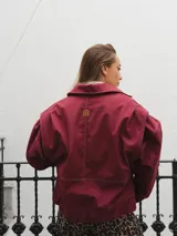 Campera gris con cierre frontal, cuello camisero y mangas largas con puños elásticos.