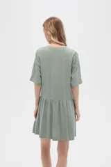 Vestido corto de algodón color verde, con cuello en V, cierre frontal de botones y diseño holgado con falda fruncida.