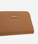 Billetera pequeña de poliuretano texturizado color tostado, con cierre perimetral de cremallera, correa de mano extraíble y detalle metálico decorativo en el frente.