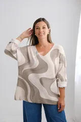Sweater de punto amplio con escote en V y mangas largas, presenta un diseño estampado con ondas abstractas en tonos beige y verde oliva.