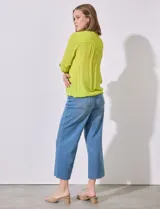 Blusa color amarillo de gasa marca Zac & Rachel, con cuello a la base, escote en V y abertura central con botones. Delantera con bolsillo aplicado. Largo de manga regulable con presilla y botón. Terminación opcional de nudo en ruedo.