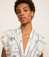 Mono corto de tricolina con estampado de cocoteros, cuello en V y lazo lateral.