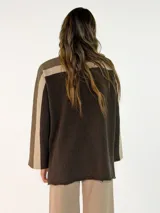 Sweater de punto con diseño color block en tonos gris oscuro, negro y gris claro. Presenta cuello alto, mangas largas y un corte holgado.