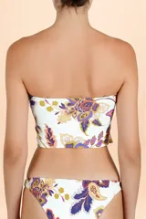 Top de bikini con escote recto y breteles finos, presenta un diseño con volado asimétrico en la base y estampado botánico multicolor sobre fondo blanco.