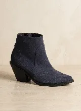 Bota corta de cuero vacuno en color azul oscuro, con diseño de caña media, punta almendrada y taco cuadrado de 7 cm. Presenta costuras decorativas laterales y suela de caucho antideslizante.