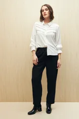 Camisa verde clara de manga larga confeccionada en viscosa ligera, con cuello clásico, cierre frontal con botones, detalles calados en la parte superior y pequeños volados.